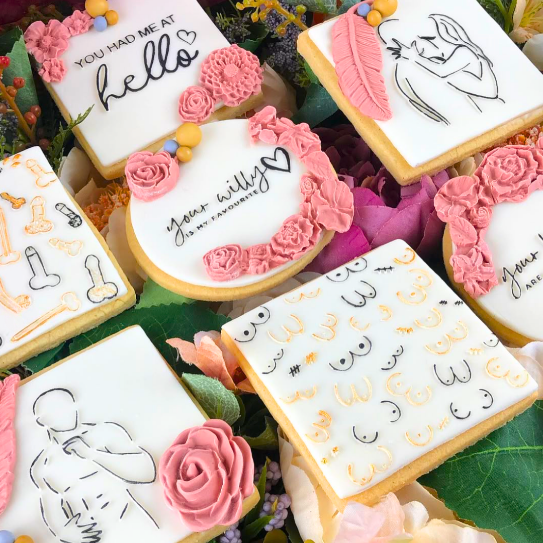 Decorative cookies with floral designs and text on a green leaf background