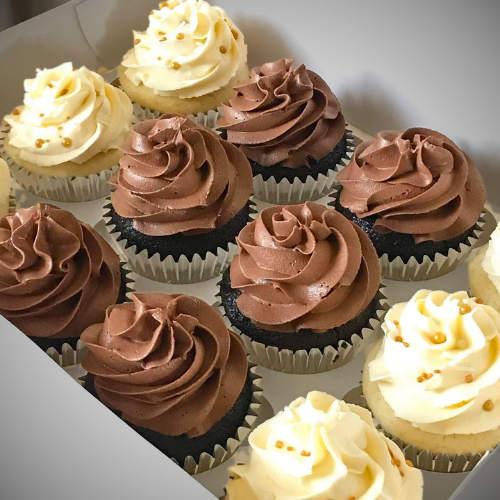 Assorted cupcakes with chocolate and vanilla frosting on a white plate.
