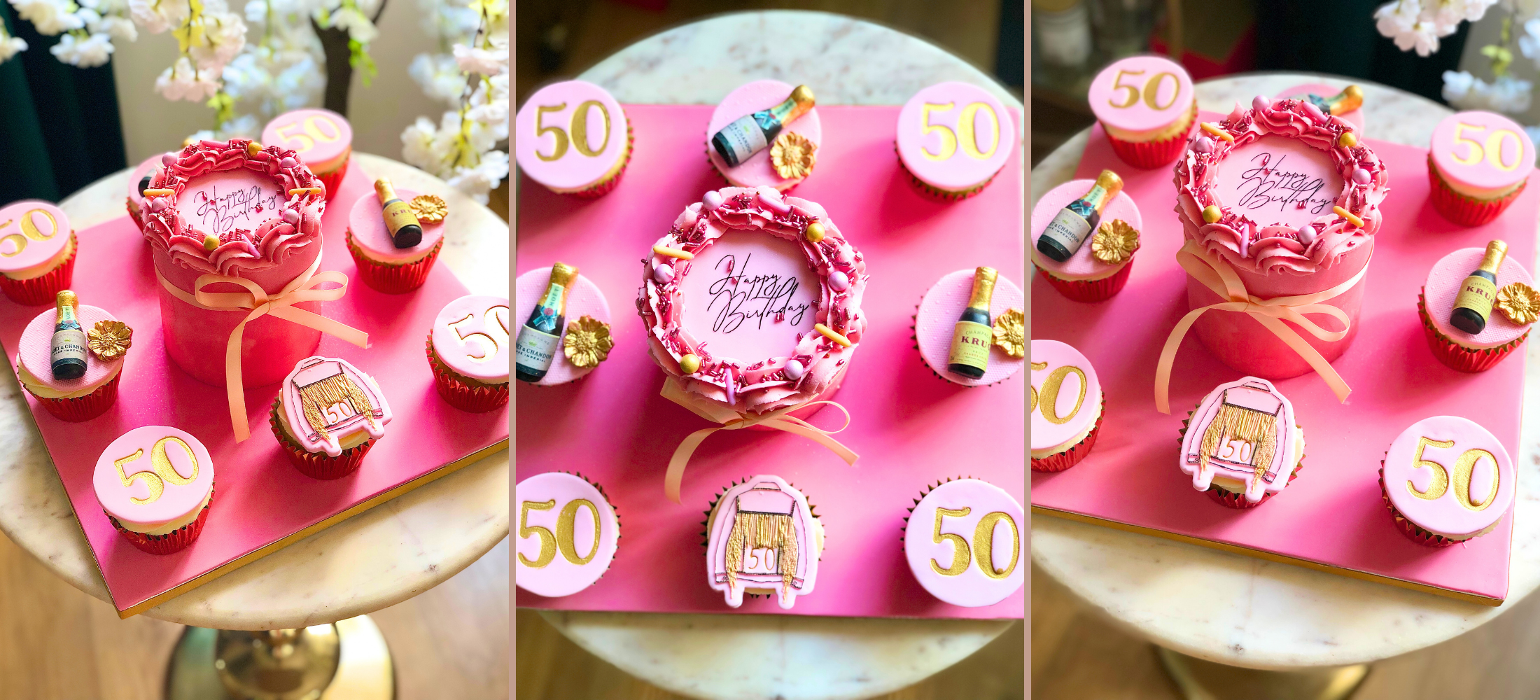Decorative cake with 'Happy 50th' on a pink board with small cakes and decorative items.